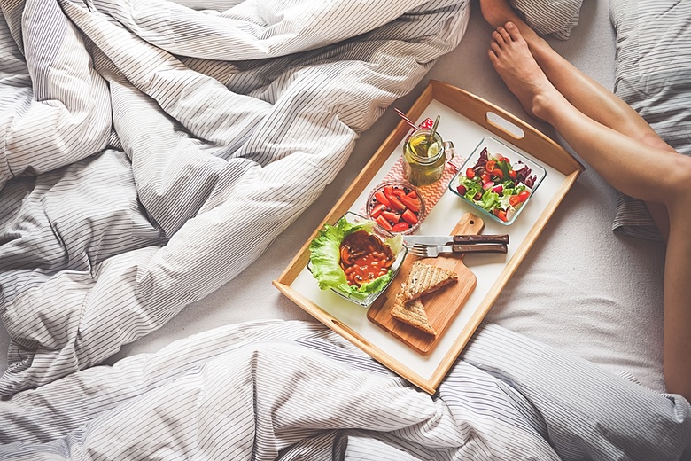 Young Woman Enjoying Morning Breakfast in Bed