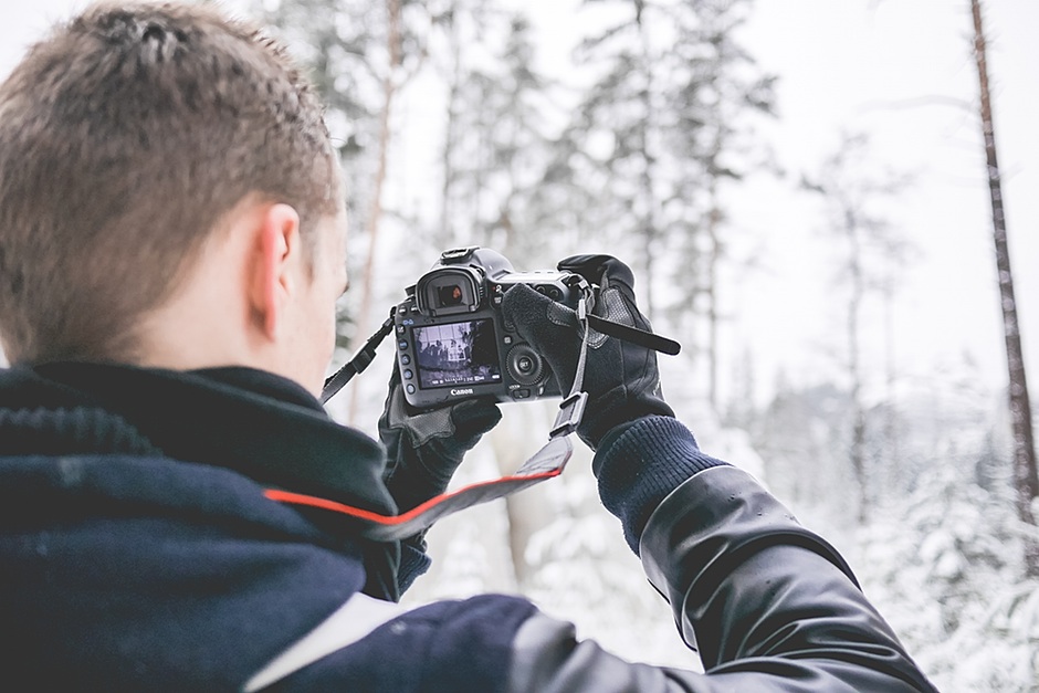Photographer in Snowy Forest Taking Winter Photos